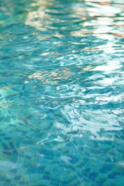 Yüzme havuzunun kareli seramikleriyle dolu berrak ve mavi yüzme havuzu.