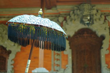 Tipik Bali tarzı bir binanın önündeki tipik Bali kumaşından yapılmış bir şemsiye.