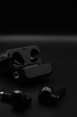 Siyah arka planlı siyah TWS kulaklıklar