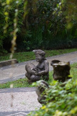 Bali heykeli, Balili bir adam şeklinde oyulmuş. Elinde geleneksel bir müzik aleti var..