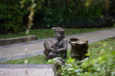 Bali heykeli, Balili bir adam şeklinde oyulmuş. Elinde geleneksel bir müzik aleti var..