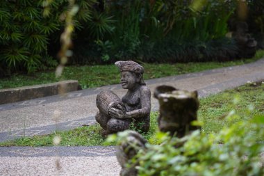 Bali heykeli, Balili bir adam şeklinde oyulmuş. Elinde geleneksel bir müzik aleti var..