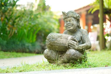 Bali heykeli, Balili bir adam şeklinde oyulmuş. Elinde geleneksel bir müzik aleti var..