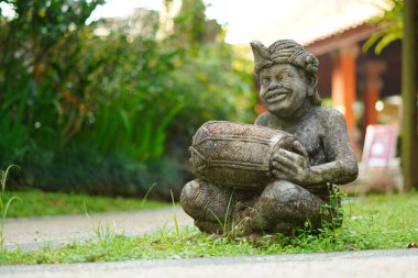 Bali heykeli, Balili bir adam şeklinde oyulmuş. Elinde geleneksel bir müzik aleti var..