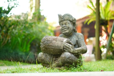 Bali heykeli, Balili bir adam şeklinde oyulmuş. Elinde geleneksel bir müzik aleti var..
