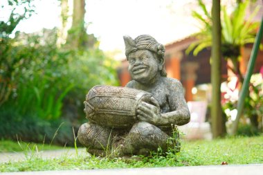 Bali heykeli, Balili bir adam şeklinde oyulmuş. Elinde geleneksel bir müzik aleti var..