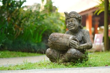 Bali heykeli, Balili bir adam şeklinde oyulmuş. Elinde geleneksel bir müzik aleti var..