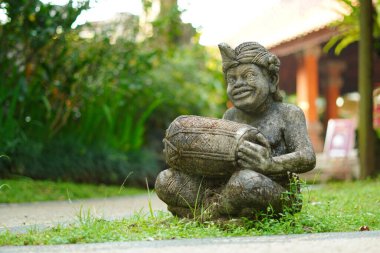 Bali heykeli, Balili bir adam şeklinde oyulmuş. Elinde geleneksel bir müzik aleti var..