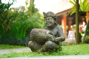 Bali heykeli, Balili bir adam şeklinde oyulmuş. Elinde geleneksel bir müzik aleti var..