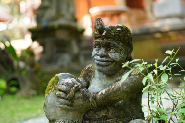 Bali heykeli, Balili bir adam şeklinde oyulmuş. Elinde geleneksel bir müzik aleti var..