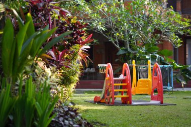 Sabahları parkın ortasında çocuklar için plastik kaydırak ve salıncak oyuncakları