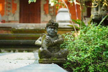 Bali heykeli, Balili bir adam şeklinde oyulmuş. Elinde geleneksel bir müzik aleti var..