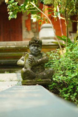 Bali heykeli, Balili bir adam şeklinde oyulmuş. Elinde geleneksel bir müzik aleti var..