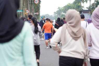 Sabah egzersizi için arabasız gezen bir grup insan.