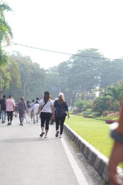 Bir grup insan sabah araba kullanmadan ana yolda yürüyor.