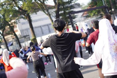 Siyah elbiseli bir adam arabasız bir günde sabah egzersizi yapıyor.