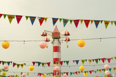 Küçük bayrakları ve şenlikli süslemeleri olan bir karnavalda kule gezintisi.
