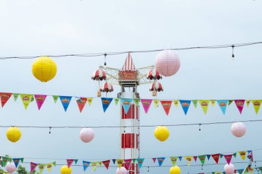 Şu anda karnaval alanında asılı duran karnaval dekorasyonlarıyla çalışmayan iniş kulesinin tepesi.