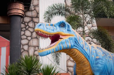 Mavi T-Rex dinozor heykeli açık hava karnavalında ağzını açıyor
