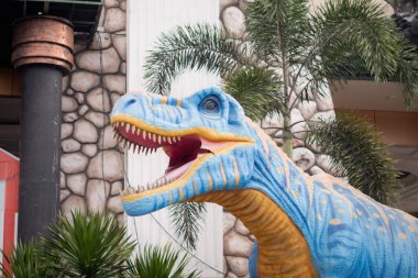 Mavi T-Rex dinozor heykeli açık hava karnavalında ağzını açıyor