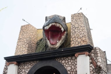 T-rex baş heykeli. Giriş kapısında ağzı açık.