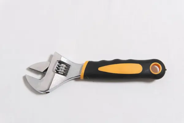 Siyah ve sarı saplı beyaz arka planda ayarlanabilir metal anahtar