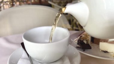 Rahatlatıcı lüks arka planda süt dökülen bir fincan çay. Odaklan. Yüksek kalite 4k görüntü