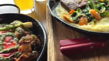 Izgara sebze püresi patates püresi ve sığır dili ya da iki kişilik öğle yemeğine limonlu bira ve limon suyu ile sunulmuş güzel bir biftek. Yüksek kalite 4k görüntü