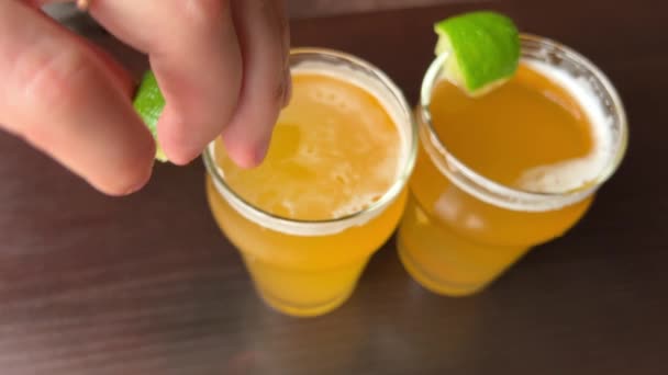 Womans Hand Squeezes Lemon Juice Glass Beer Table Two Glasses — Vídeo de Stock