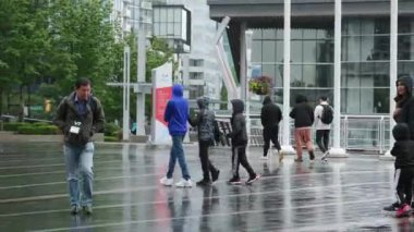 Kanada 'nın göbeğinde yağmurlu bir bahar var. Büyük anne ve büyük baba, şemsiyeli kadın ve erkekler, valizli insanlar, şehirde gezen yerel turistler. Merkezde yağmur var. Vancouver Kanada İngiliz Kolombiyası 05.04.2024