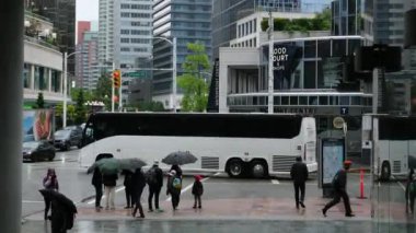 Kanada 'nın göbeğinde yağmurlu bir bahar var. Büyük anne ve büyük baba, şemsiyeli kadın ve erkekler, valizli insanlar, şehirde gezen yerel turistler. Merkezde yağmur var. Vancouver Kanada İngiliz Kolombiyası 05.04.2024