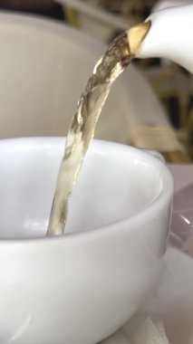 Rahatlatıcı lüks arka planda süt dökülen bir fincan çay. Odaklan. Yüksek kalite 4k görüntü