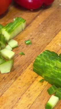 El, Salatalık Yüzüklerini Kesiyor. Tahta kesme tahtasının üzerinde taze salatalık kesen eller. Pişirmek için bıçakla sebze dilimlemek. Stok görüntüleri. - Evet. Yüksek kalite 4k görüntü