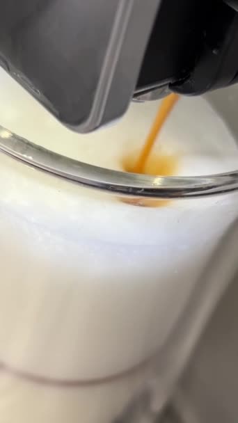 ミルクでガラスカップに注ぐコーヒーのショットを閉じて 自動コーヒーマシンを使用してカプチーノを作ります 高品質の4K映像 — ストック動画