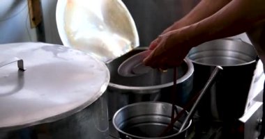 Vietnam 'da sokak yemeklerinde sahte çorba pişirmek sağlıksız koşullar turistlerin en sevdiği Asya çorbası. Erkek satıcı pirinç vermicelli çorbası hazırlıyor.