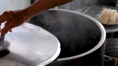 Vietnam 'da sokak yemeklerinde sahte çorba pişirmek sağlıksız koşullar turistlerin en sevdiği Asya çorbası. Erkek satıcı pirinç vermicelli çorbası hazırlıyor.