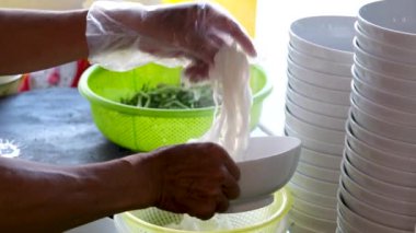 Vietnam 'da sokak yemeklerinde sahte çorba pişirmek sağlıksız koşullar turistlerin en sevdiği Asya çorbası. Erkek satıcı pirinç vermicelli çorbası hazırlıyor.