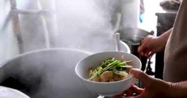 Vietnam 'da sokak yemeklerinde sahte çorba pişirmek sağlıksız koşullar turistlerin en sevdiği Asya çorbası. Erkek satıcı pirinç vermicelli çorbası hazırlıyor.