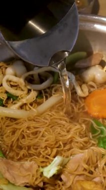 Tom Yam baharatlı çorba. Vietnam 'da hazır şehriye çorbası pişir. Masanın ortasında bir restoran aşçısında. Restoranda geleneksel Asya mutfağını pişir. Yüksek kalite 4k görüntü