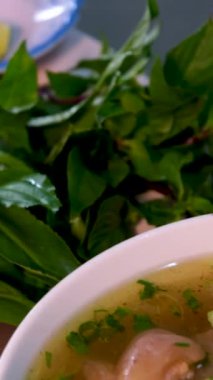 Vietnam 'da sokak yemeklerinde sahte çorba pişirmek sağlıksız koşullar turistlerin en sevdiği Asya çorbası. Erkek satıcı pirinç vermicelli çorbası hazırlıyor.