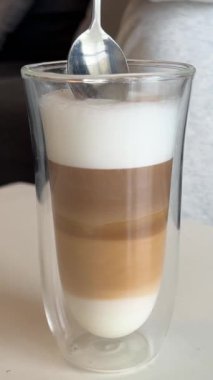 Cappuccino ve Tarçın. Kahvaltı Sütlü Süt Köpüklü Latte Bar 'da Macchiato kahvesi. Tarçın ve kakule kahve dükkanında kapuçino ve karıştırıcı köpük şekeri..