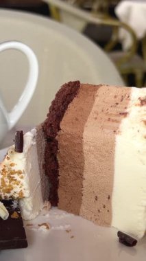 Üçlü çikolatalı kremalı pastayı çatalla yakın plan yiyorum. Yüksek kalite 4k görüntü