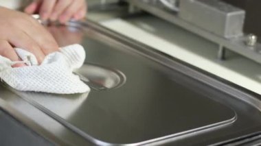 Önlüklü tanınmayan bayan barista kafe garsonu. Özel kıyafetler giyiyor. Masa temizliyor. Lekeleri çıkarıyor. 4k