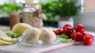 Kaşık üzerinde taze mozzarella peyniri topları. Çeri domatesli mozzarellalı cam tabak sağlıklı bir içecek.