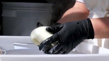 Caciocavallo kabak peyniriyle ev yapımı peynir fabrikasında adım adım kachakovala peyniri nasıl hazırlanır? Siyah lateks eldivenli kadın elleri İtalya 'da lezzetli bir ürün hazırlar. 4k