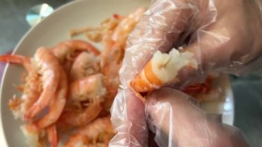 Çıplak elle haşlanmış karides kabuğu soymak. Seçici odaklanma. Yüksek kalite 4k görüntü