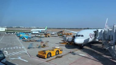 Havaalanı havaalanı Pisti Katar Havayolları bagaj yükleme uçakları havaalanındaki pencere fırlatma alanı işçilerinden bagaj görüntüsü yükleme. Katar Doha 05.05.2024