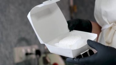 Fransız organik keçi peyniri konsepti Picodon, Fransa 'nın güneyindeki tahta tahtada fotokopi uzayını oluşturur. Siyah eldivenli kadın elleri peynir paketleri