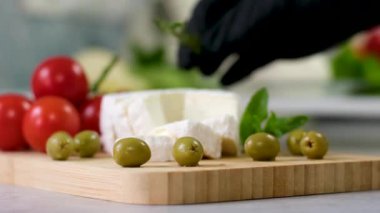 picadon peyniri ünlü Fransız keçi peyniri. Taze peynirli ve aromalı. Domatesli ve taze otlu ahşap kesim tahtasındaki peynir. Yüksek kalite 4k