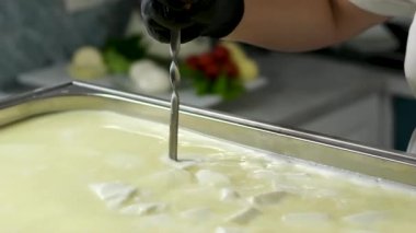 Kachakovala Caciocavallo peynir hazırlama süreci. Siyah lateks eldivenli kadın elleri peynir fabrikasındaki özel peynir fabrikasından peynir parçaları çıkarıyor. Yüksek kalite 4k